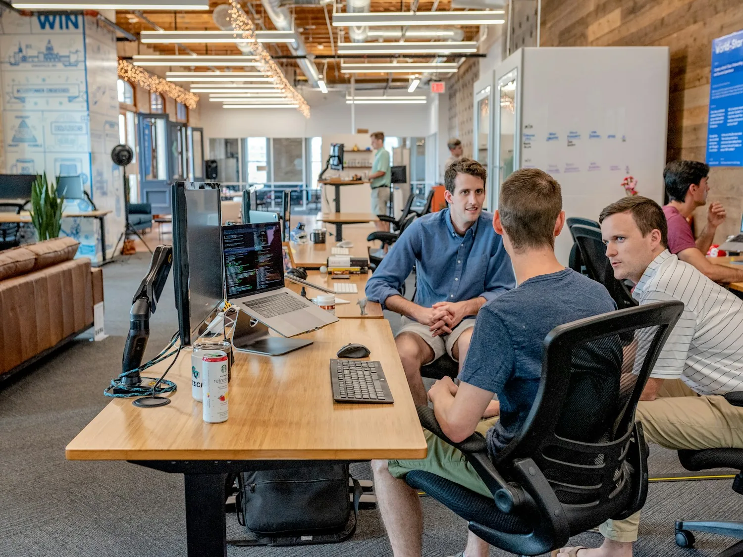 Colleagues discussing work around a table in a bright office